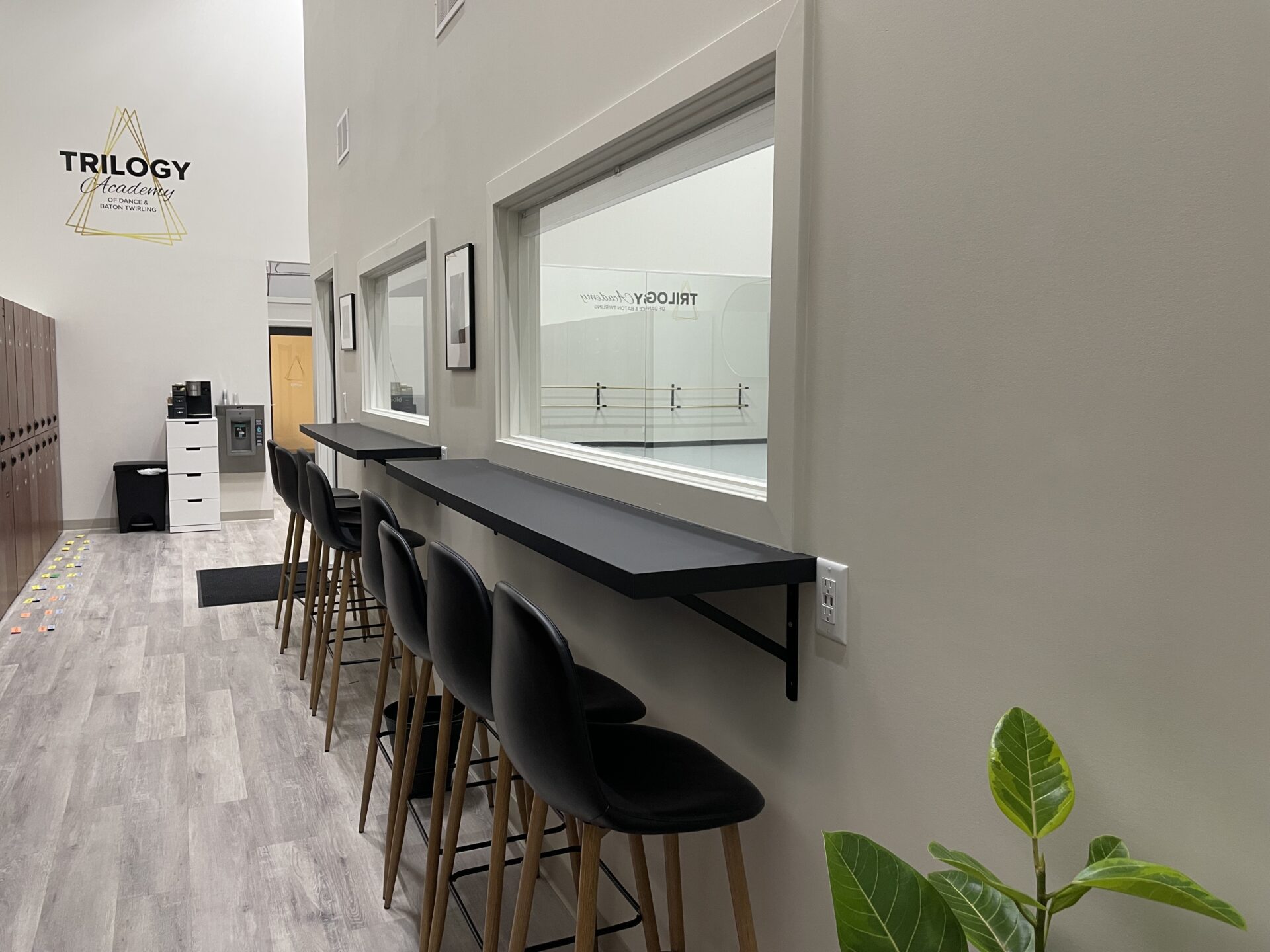 Black chairs with black desks attached, positioned near the window of Trilogy Dance Academy